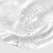 Close-up of Hale & Hush Quiet Wash showing a lightweight clear gel cleanser texture with bubbles on a light gray background