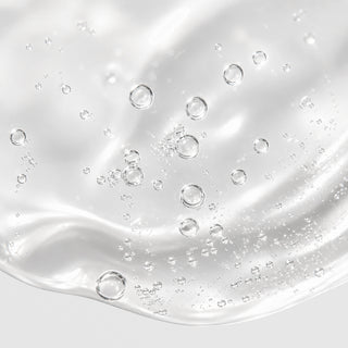 Close-up of Hale & Hush Quiet Wash showing a lightweight clear gel cleanser texture with bubbles on a light gray background