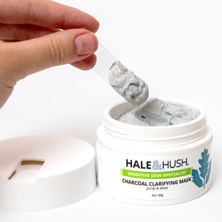 Hale & Hush Charcoal Clarifying Mask open jar with spatula scooping gray clay mask, Sensitive Skin Specialist label visible, 3oz 86g

