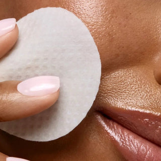 Woman applying RetaXome Retinal Boost Treatment Pad to cheek near mouth