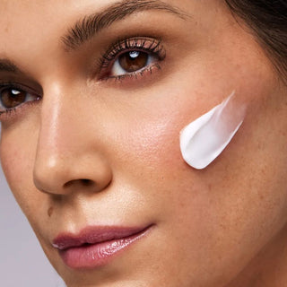 Woman applying Hydrinity Célthera Advanced Overnight Repair Cream to her cheek