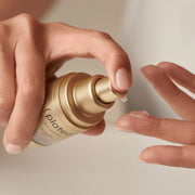 Hands pumping Plated Skin Science INTENSE Serum onto fingertip, showing lightweight serum texture and easy pump application