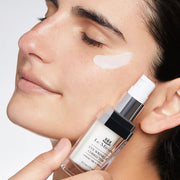 Model applying Le Mieux Eye Wrinkle Corrector 0.5 oz under eye area with product bottle held alongside face.
