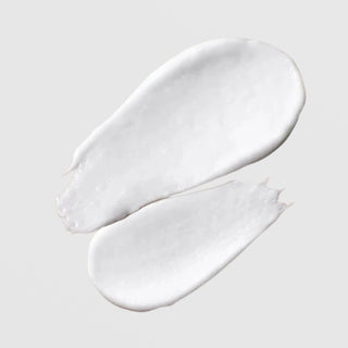 Le Mieux Microderm Exfoliant texture swatches showing creamy white exfoliating scrub formula with visible granules on grey background.