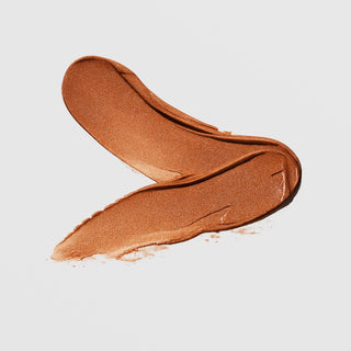 Le Mieux Naked Glow Bronzer SPF 50 texture swatch showing rich copper bronze shimmer cream formula on grey background.