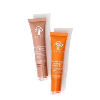 Two tubes of Circadii lip renewing hydrator skincare on a white background, one in a warm brown shade and one in a bright orange shade.