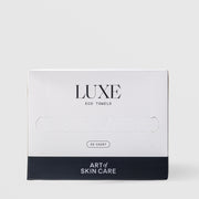 Art of Skin Care Luxe Eco Towels 50-count box closed, showing the white and navy packaging with a perforated dispensing slot, displayed against a light gray background.