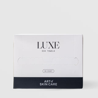 Art of Skin Care Luxe Eco Towels 50-count box closed, showing the white and navy packaging with a perforated dispensing slot, displayed against a light gray background.