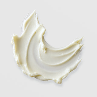 Michele Corley Calming Moisture Cream texture swatch showing rich thick off-white cream formula with swirled peaks on grey background.