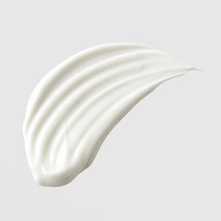 Michele Corley Gentle Cleansing Milk texture swatch showing soft white creamy milk cleanser formula with smooth ridges on grey background.