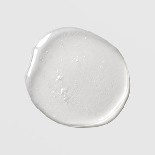Michele Corley Mandelic Niacinamide Serum Plus texture swatch showing lightweight clear gel serum with fine bubbles on grey background.