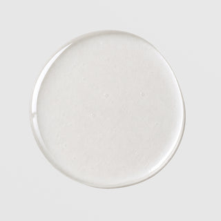Michele Corley Pore Clearing Cleansing Oil texture drop showing lightweight milky white cleansing oil formula on grey background.