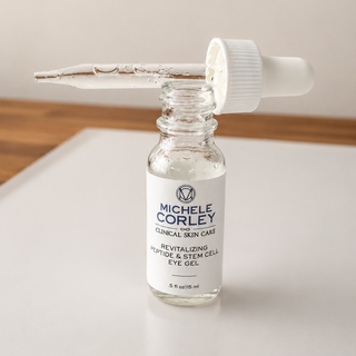 Michele Corley Clinical Skin Care Revitalizing Peptide and Stem Cell Eye Gel 0.5 oz clear glass dropper bottle open on marble surface.