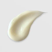 Michele Corley Ultra Rich Moisture Cream texture swatch showing dense creamy off-white formula on grey background.