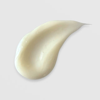 Michele Corley Ultra Rich Moisture Cream texture swatch showing dense creamy off-white formula on grey background.