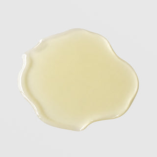 Michele Corley Vitamin C Serum Plus texture swatch showing lightweight pale yellow vitamin C serum formula on grey background.