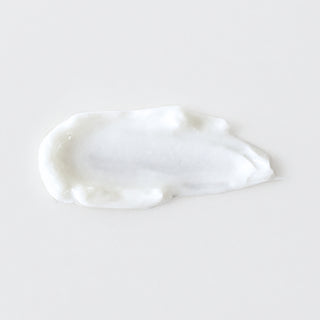 Mixi Hydroxi Acne Cream texture swatch showing lightweight white acne treatment cream formula on grey background.