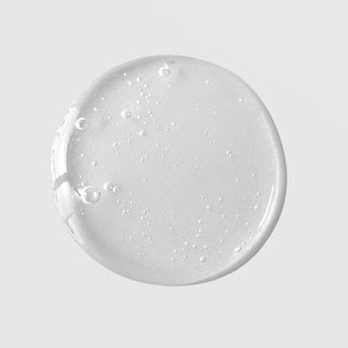 Mixi Mandelic Serum texture drop showing lightweight clear gel serum with fine bubbles on grey background.