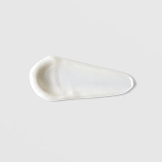 Mixi SPF 50 Mineral Sunscreen texture swatch showing smooth white mineral sunscreen formula on grey background.