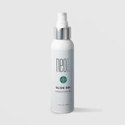 NeoGenesis Glide Gel Conductive Gel 120 mL in a tall white pump bottle with chrome silver collar and teal four-petal icon label on a light gray background