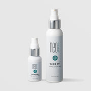 NeoGenesis Glide Gel Conductive Gel in two sizes: 30 mL and 120 mL, shown side by side in white pump bottles with chrome silver collars and teal four-petal icon labels on a light gray background