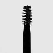 Close-up of NeoGenesis NeoBrow Growth Serum spoolie brush applicator loaded with serum on a light gray background