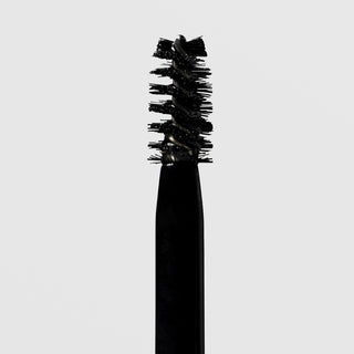 Close-up of NeoGenesis NeoBrow Growth Serum spoolie brush applicator loaded with serum on a light gray background