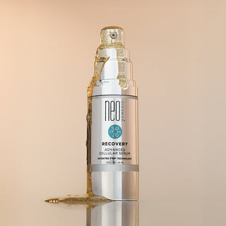NeoGenesis Recovery Serum with serum dripping down and puddling next to the bottle on a beige background