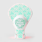 Omnilux Contour Glove LED device in a hand-shaped silicone form with a white and teal floral line pattern, pink accents, a wrist strap, and a central Omnilux Contour control hub, displayed against a light gray background.