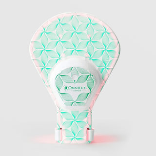 Omnilux Contour Glove LED device in a hand-shaped silicone form with a white and teal floral line pattern, pink accents, a wrist strap, and a central Omnilux Contour control hub, displayed against a light gray background.