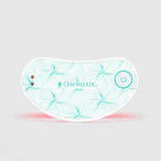 Omnilux Mini Eye Brightener LED device in a curved under-eye shape with a white and teal floral line pattern, power button, and visible red LED light glow along the bottom edge, displayed against a light gray background.