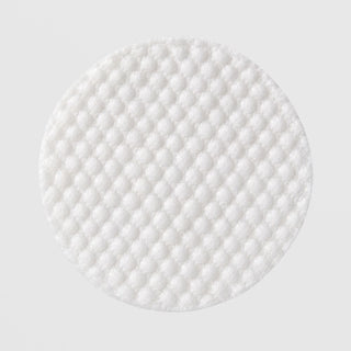 Close-up of (plated) Exosome Enhancer Daily Prep Pad showing textured white quilted surface for gentle exfoliation