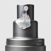 Close-up of Plated Skin Science DAILY Serum pump nozzle dispensing lightweight clear gel serum with micro-bubbles on silver metallic bottle
