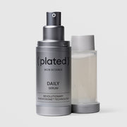 Plated Skin Science DAILY Serum silver airless pump bottle beside its refillable inner cartridge, highlighting sustainable refillable packaging