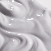 Close-up texture shot of iS Clinical Reparative Moisture Emulsion showing a rich creamy white emulsion with a smooth silky consistency