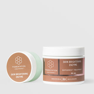 Rhonda Allison Pigmentation Solutions Skin Brightening Enzyme Depigment Treatment shown in both sizes: small travel jar leaning on its side and 50mL upright white jar with terracotta brown honeycomb labels on a light gray background