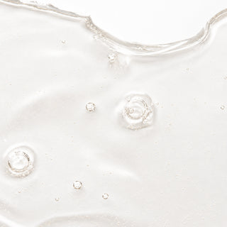 Close-up texture shot of SIV Biome Balancing Serum showing a lightweight clear gel with small air bubbles on a white surface