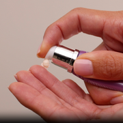 Dispensing a small amount of GlyMed Plus Firming Eye Cream from the pump applicator into hand