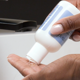 Pouring GlyMed Plus Accelerator Gel with 20% Alpha Hydroxy Acids from white bottle into palm of hand