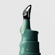 Close-up of Plated Skin Science Eye Serum teal bottle showing serum-coated cooling metal roller ball applicator tip