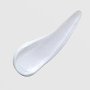 Skin Script Hydrating Moisturizer texture swatch showing glossy white cream formula on grey background.