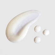 Skin Script Mandelic Brightening Serum texture swatch showing smooth pearlescent white cream with rich fluid consistency displayed as a swipe alongside several individual drops. Available at Art of Skin Care