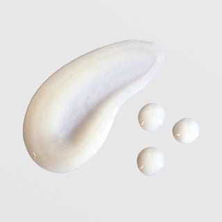 Skin Script Mandelic Brightening Serum texture swatch showing smooth pearlescent white cream with rich fluid consistency displayed as a swipe alongside several individual drops. Available at Art of Skin Care