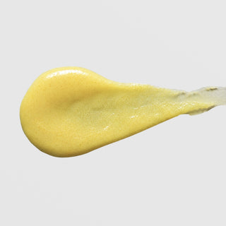 Skin Script Retinol Exfoliating Scrub texture swatch showing yellow scrub formula with visible exfoliating granules on grey background.
