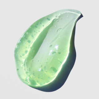 Close-up texture swatch of the Skin Script Revitalizing Cucumber Treatment gel, available at Art of Skin Care. The light green, translucent gel has a smooth, lightweight, water-based consistency ideal for soothing, hydrating, and calming sensitive or irritated skin