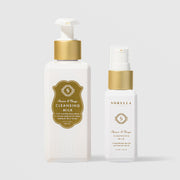 Sorella Apothecary Apricot and Mango Cleansing Milk shown in both 5.7 oz and 2 oz pump bottle sizes on a light gray background