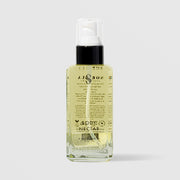 Sorella Apothecary Body Nectar in a clear glass pump bottle showing the back label and golden oil formula on a light gray background