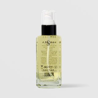Sorella Apothecary Body Nectar in a clear glass pump bottle showing the back label and golden oil formula on a light gray background