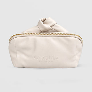 Sorella Apothecary soft cream knotted makeup bag with gold zipper and embossed logo, from the Glow Holiday Set