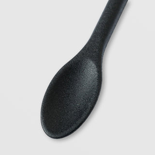 Close-up of the spoon end of the Sorella Apothecary Good to the Last Drop dual-ended spatula on a light gray background